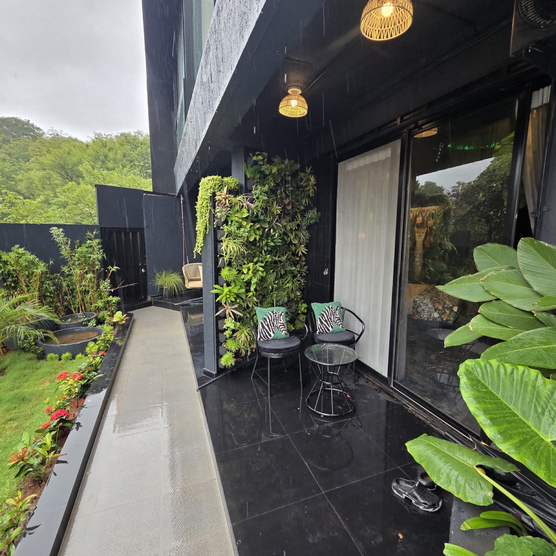 The Jungle Room's private patio with a living green wall in the rain