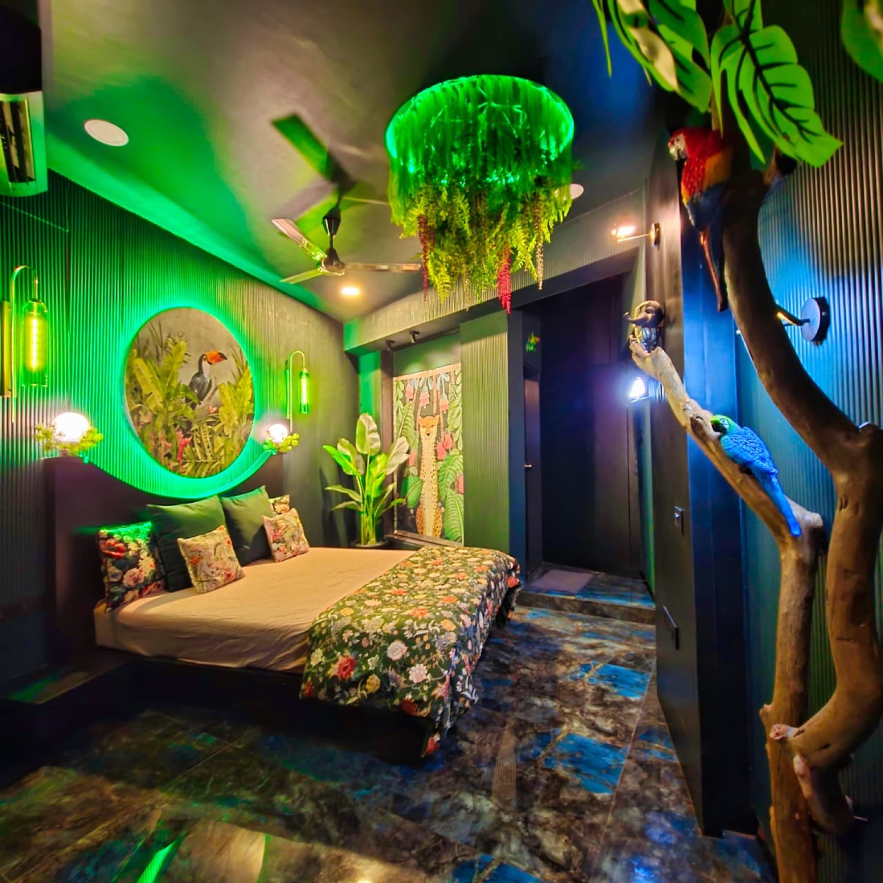 Jungle Room with rainforest murals, hanging foliage and green lighting
