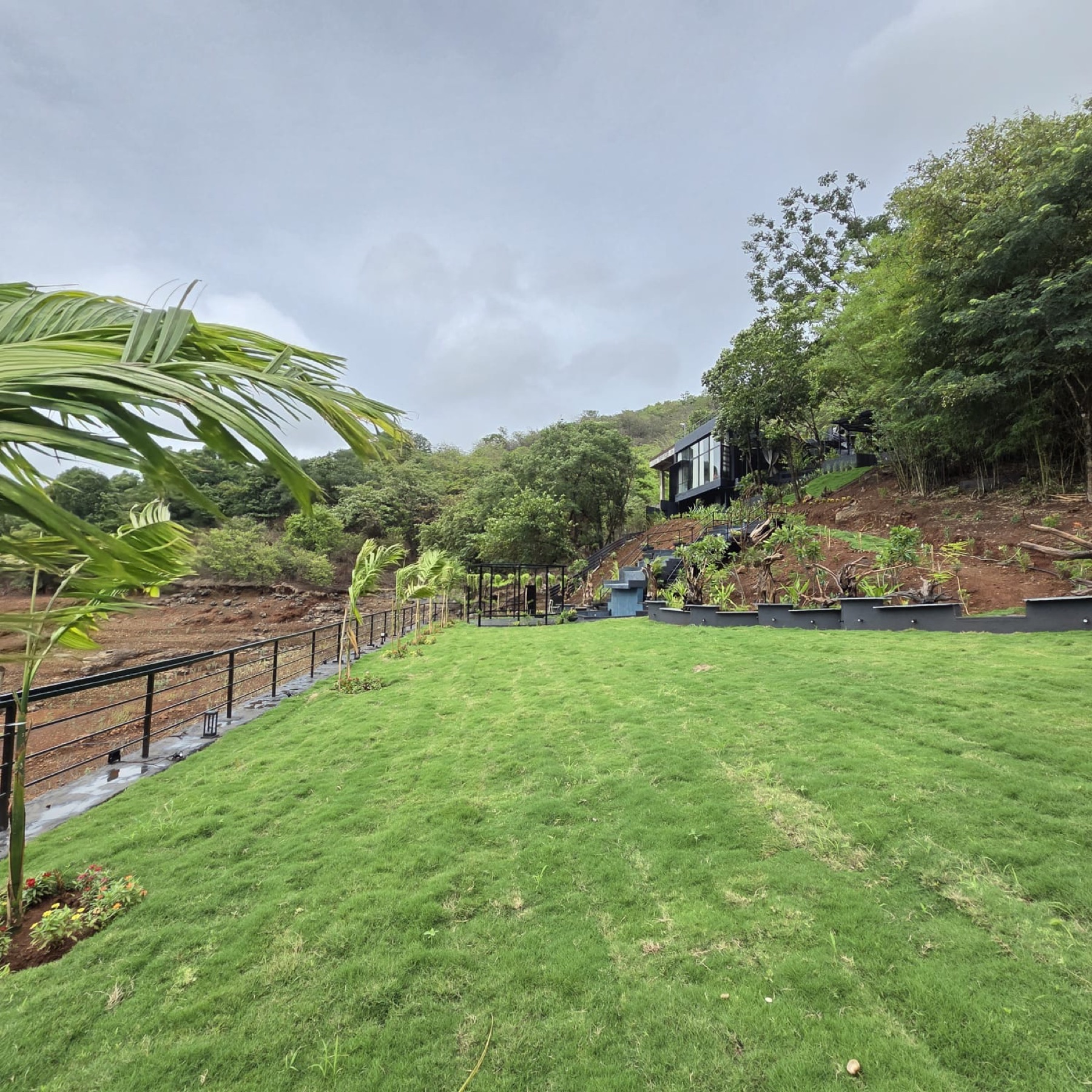 The wide lawn running to the water's edge with the villa on the ridge above