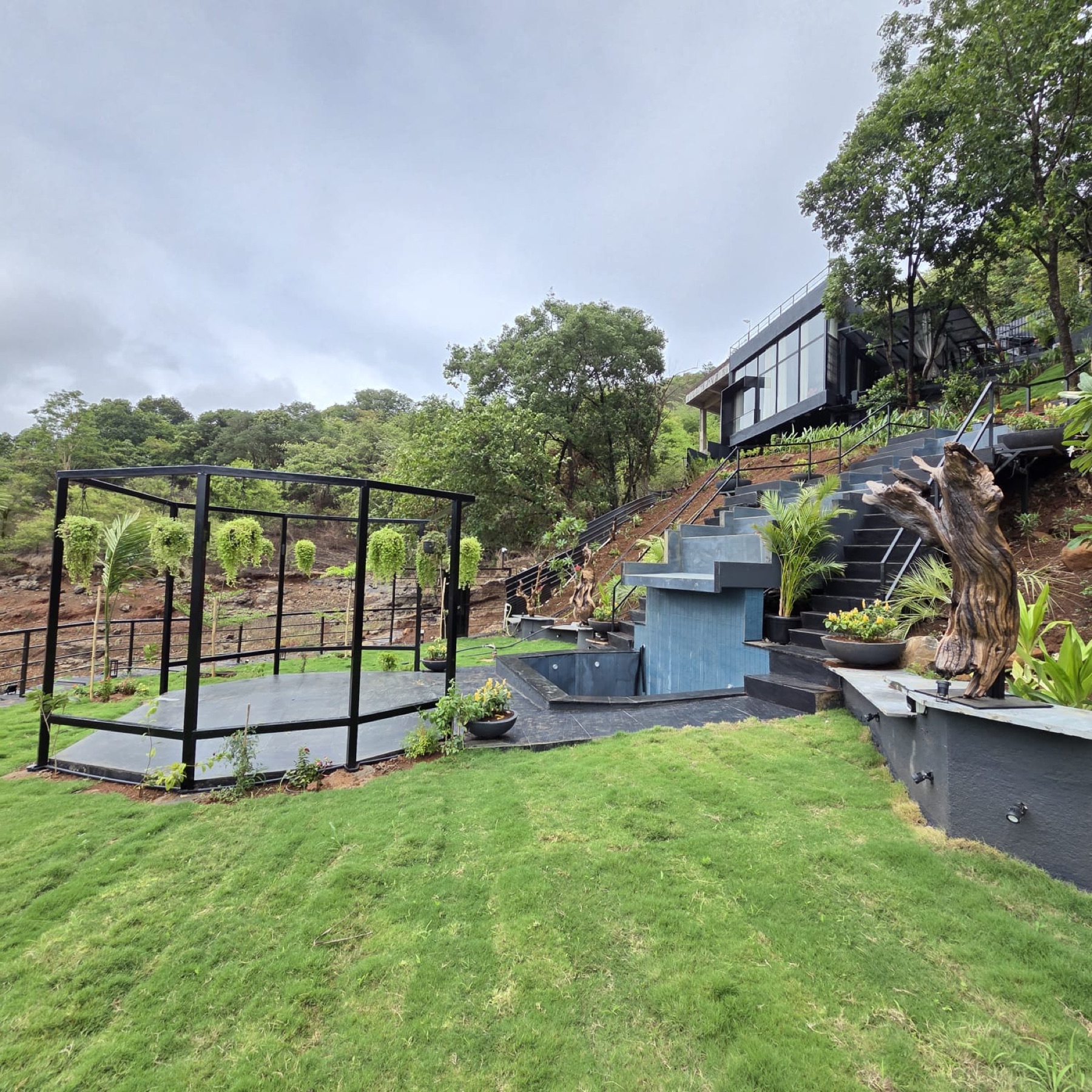 The open lawn and glass pergola with the hills behind
