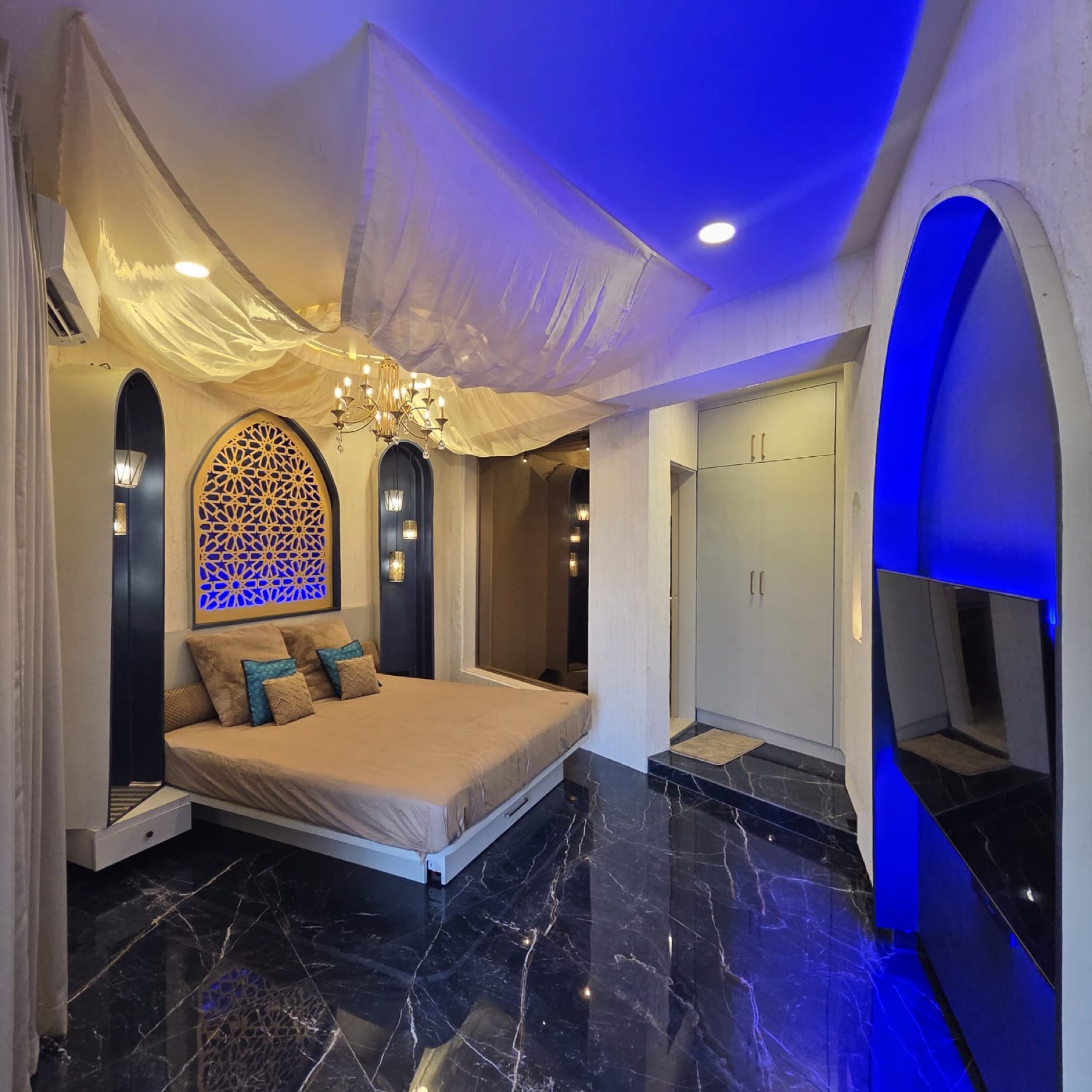 Oasis Room with Moroccan fretwork arch, draped ceiling and brass lanterns