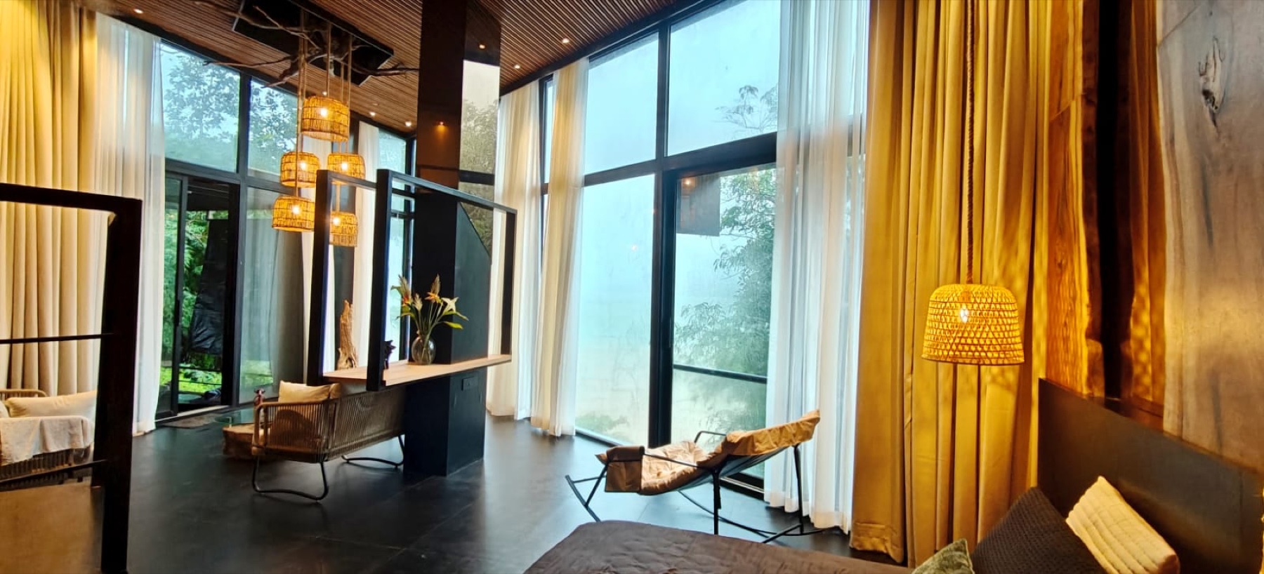 Glass Duplex Villa living room with floor to ceiling windows facing the Varasgaon lake